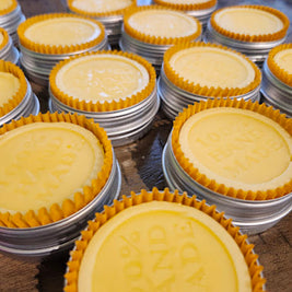 Stacks of tan lotion bars with decorative cases on a metal tray.